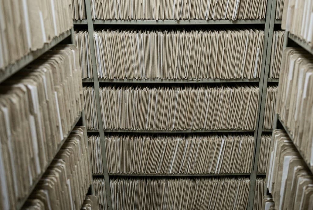 Regale voller Papierakten – Symbol für manuelle Vorgänge, die auf Automatisierung warten